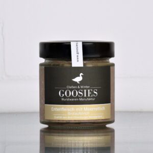 Entenfleisch mit Meerrettich der Goosies Wurstwarenmanufaktur im 175-g-Glas, auf einem Edelstahltisch vor weißem Hintergrund