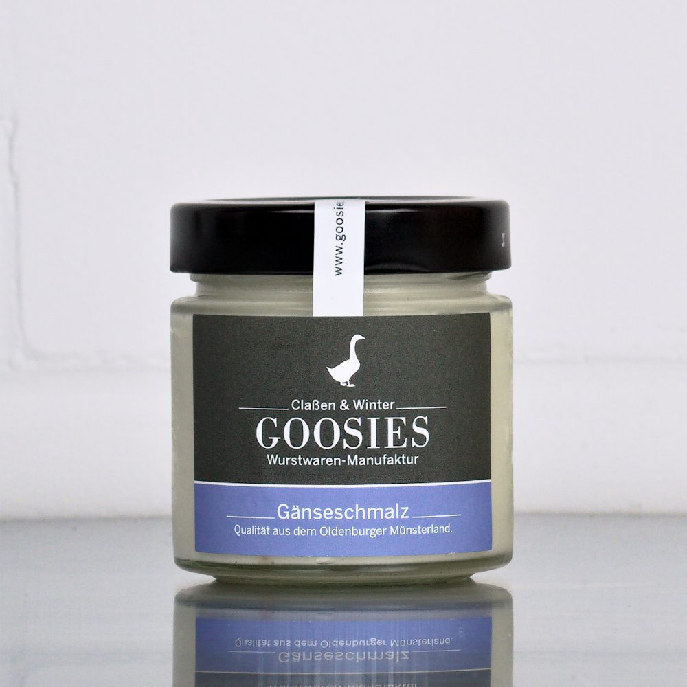 Reines Gänseschmalz der Goosies Wurstwarenmanufaktur im 150-g-Glas, auf einem Edelstahltisch vor weißem Hintergrund