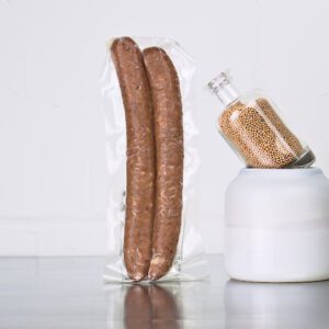 Cabanossi von der Ente der Goosies Wurstwarenmanufaktur in einer 150-g-Packung mit 2 Cabanossis auf einem Edelstahltisch vor weißem Hintergrund