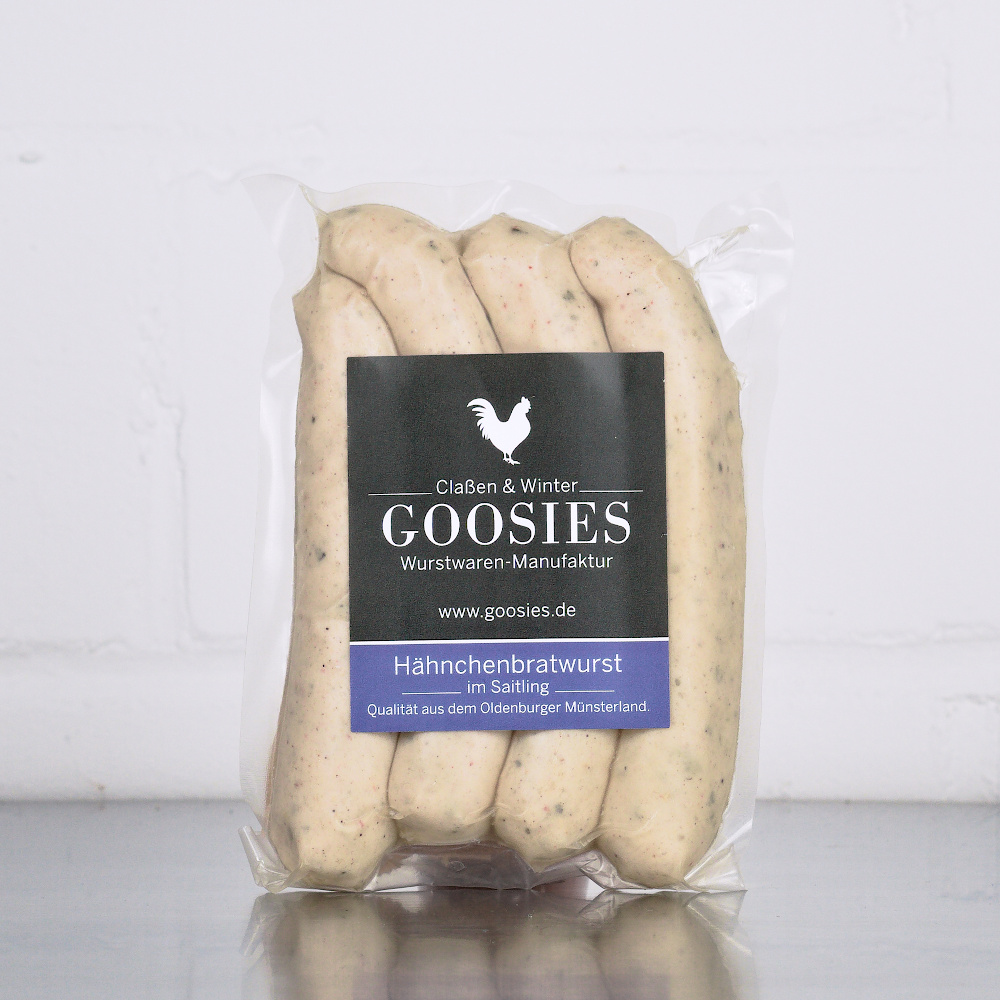 Hähnchenbratwurst der Goosies Wurstwarenmanufaktur in einer 225-g-Packung mit vier Würstchen, auf einem Edelstahltisch vor weißem Hintergrund